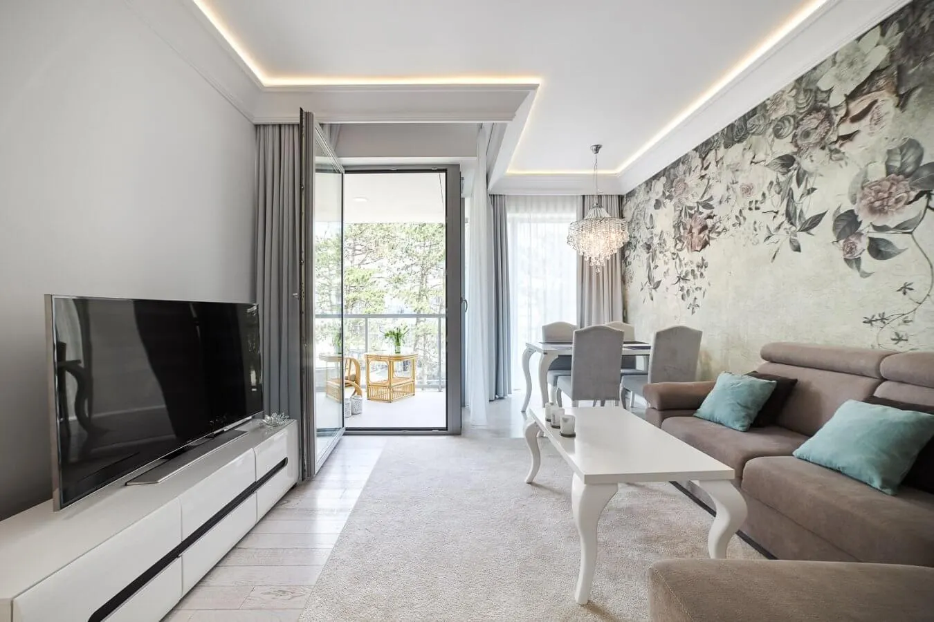 Wohnraum B321 mit Blumentapete, Esstisch und Blick auf den Balkon